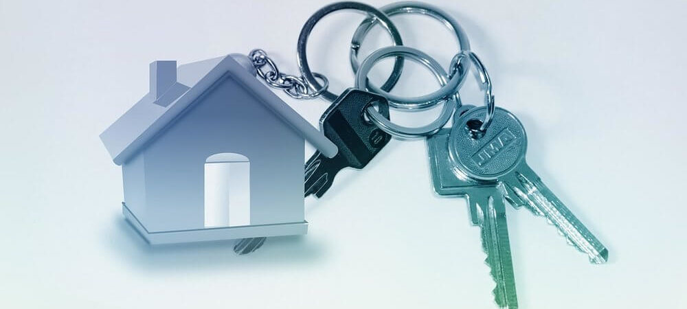 Na zdjęciu znajduje się grafika domu połączona łańcuchem z kluczami do domu. 